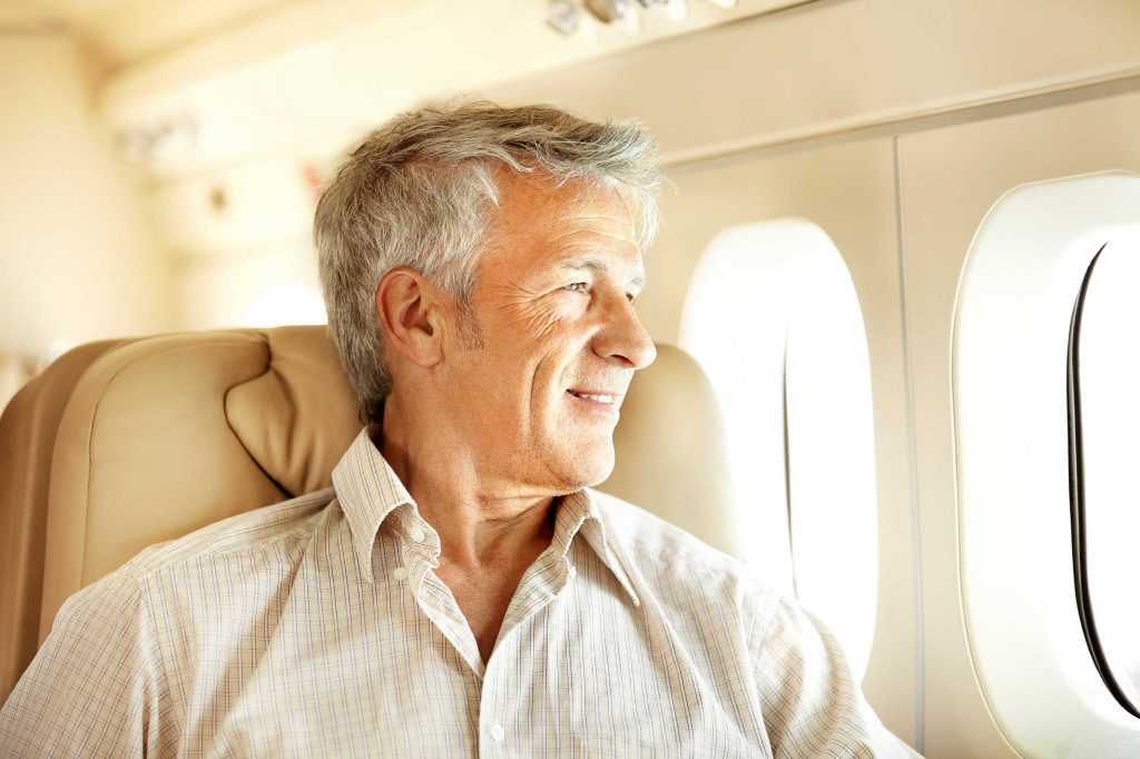 мужчина смотрит в иллюминатор самолета